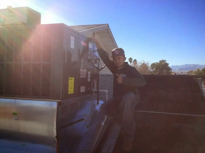 HVAC technician performing Air Duct Cleaning on a rooftop unit in Trumann